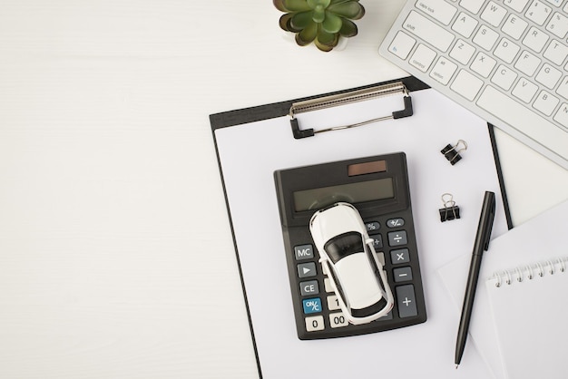 Photo Vue De Dessus Du Lieu De Travail D'affaires Avec Dossier De Papiers D'usine De Stylo De Bloc-notes Clavier Et Modèle De Voiture Sur Calculatrice Sur Fond Blanc Isolé Avec Espace De Copie