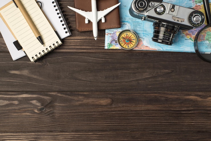 Photo vue de dessus du modèle d'avion sur la couverture du passeport appareil photo loupe et boussole sur le stylo des carnets de cartes sur fond de table en bois isolé avec fond