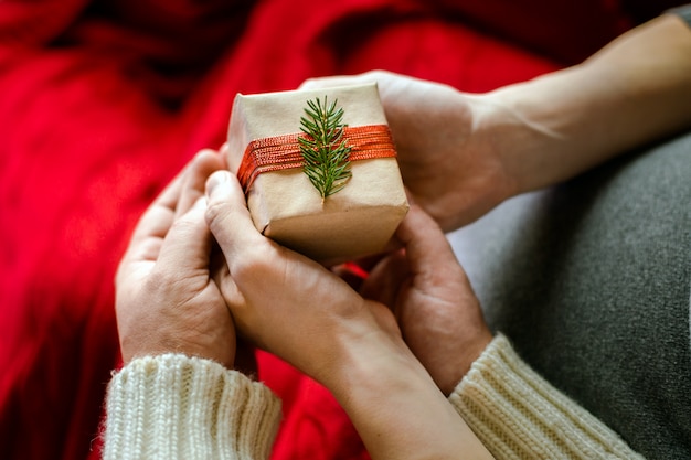 Photo vue de dessus d&#39;une main masculine et féminine avec une boîte-cadeau. Concept de fête de famille Noël et nouvel an.