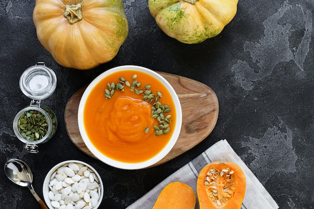 Photo vue de dessus de soupe de potiron en purée dans un bol blanc sur table sombre