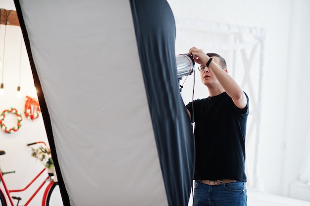 Le photographe ajuste la lumière du flash en studio.