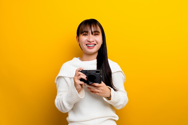 Photographe avec appareil photo les jeunes femmes aiment prendre des photos amoureux de l'appareil photo prendre des photos dans le studio jaune