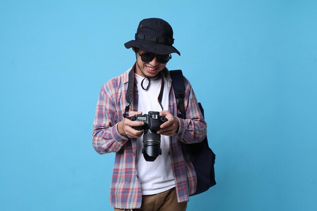 Photo un photographe asiatique souriant prend des photos avec un appareil photo reflex numérique