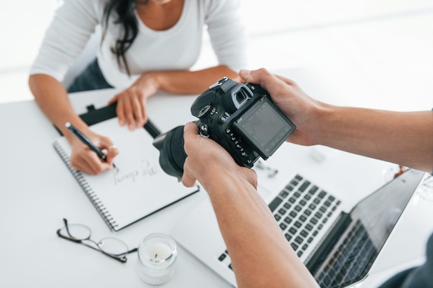 Photographe au travail Deux jeunes pigistes à l'intérieur du bureau pendant la journée