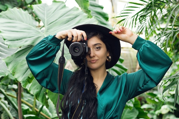 Photographe de belle femme brune avec appareil photo dans la forêt tropicale. Photo de haute qualité