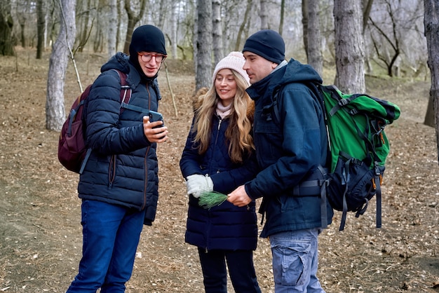 Photographe et un couple dans la forêt de fin d'hiver