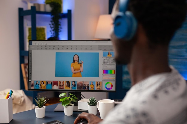 Photographe éditeur éditant des photos à l'aide d'un logiciel de retouche travaillant au contraste d'image assis au bureau dans un studio de créativité. Illustrateur professionnel faisant la correction numérique. Travail à distance