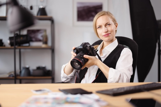 Photographe féminin réfléchi tenant l'appareil-photo dedans