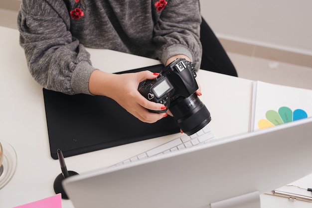 Photographe féminin travaillant au bureau dans un bureau moderne