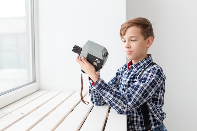 Photographe garçon tenir un vieil appareil photo rétro