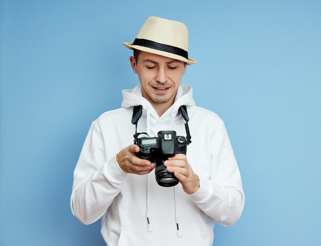 Photographe homme avec un appareil photo reflex dans ses mains prend des photos