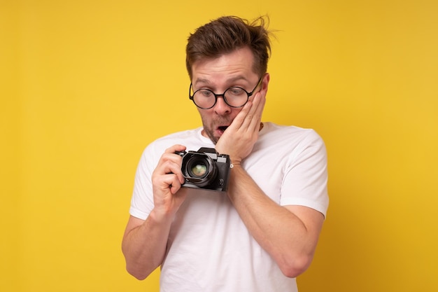 Photographe homme caucasien surpris et choqué en regardant la caméra