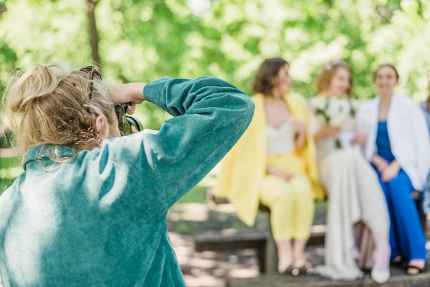 Le photographe de mariage photographie les invités des mariés dans la nature