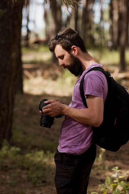 photographe naturaliste. homme avec caméra dans la forêt. envie d'errance et mode de vie de voyage