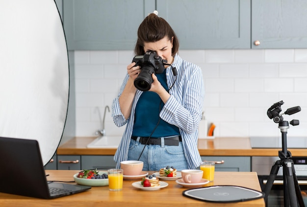 photographe de nourriture avec une caméra travaillant dans la cuisine