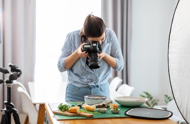 photographe de nourriture avec une caméra travaillant dans la cuisine
