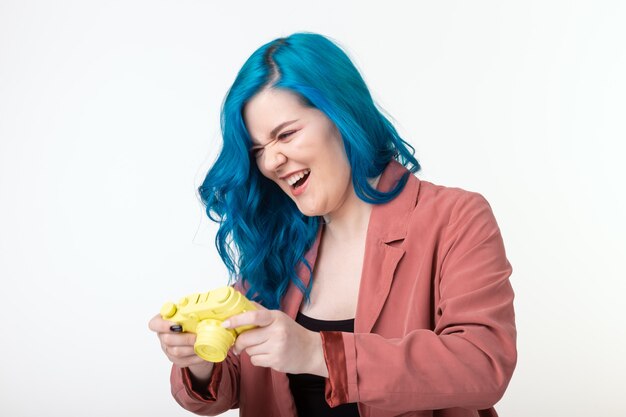 Photographe, passe-temps et concept de loisirs - jeune femme aux cheveux bleus tenant un appareil photo rétro sur fond blanc avec espace copie