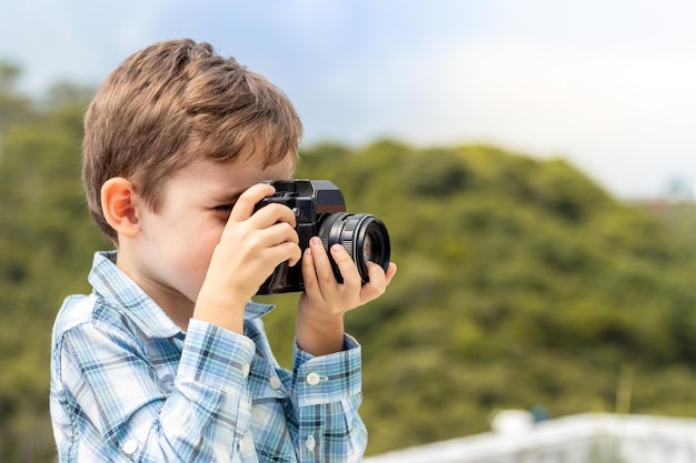 Photographe de petit garçon prenant une photo avec l'appareil photo