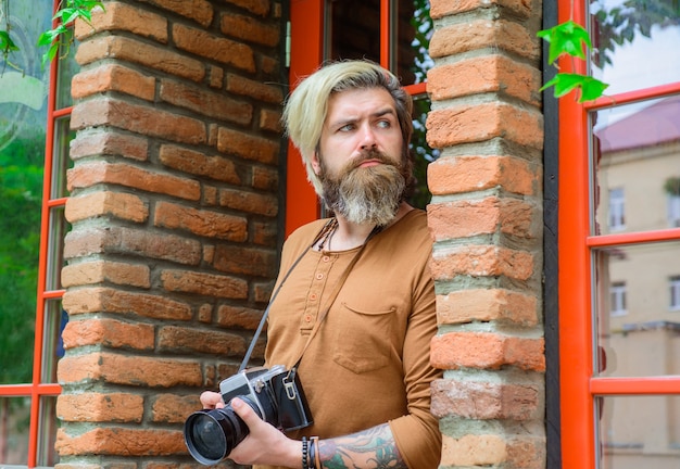 Photographe photographe masculin prenant une photo d'un homme barbu avec un professionnel de l'appareil photo professionnel