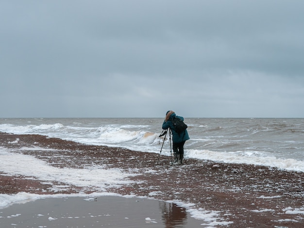 Le photographe photographie un paysage au bord de la mer déchaînée du Nord dans des conditions difficiles.