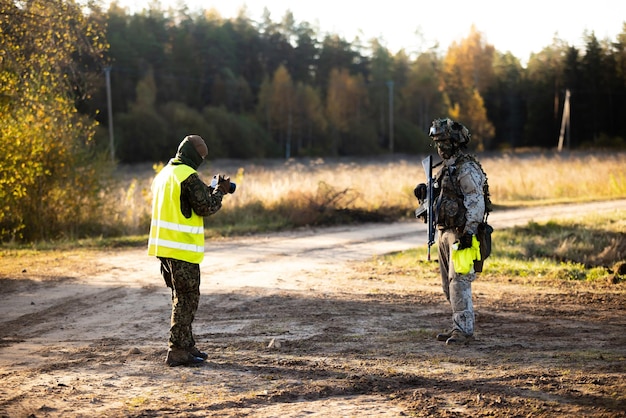 Le photographe prend une photo d'un soldat sur le champ de bataille pendant la formation