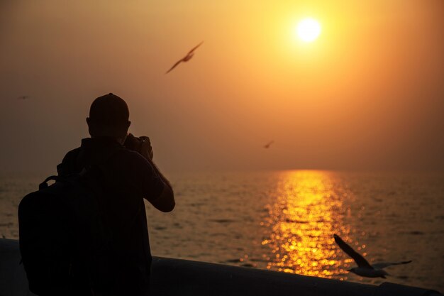 Photographe prendre une photo au coucher du soleil