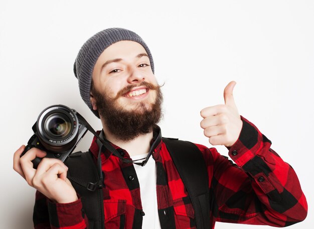 photographe professionnel. Portrait de jeune homme confiant en chemise tenant la caméra sur blanc