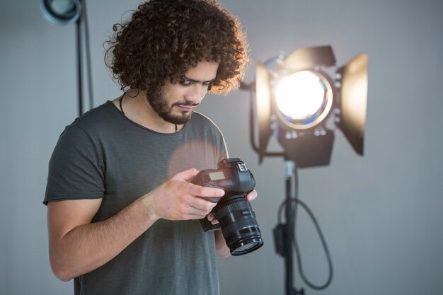 Photographe regardant les photographies dans l'appareil photo