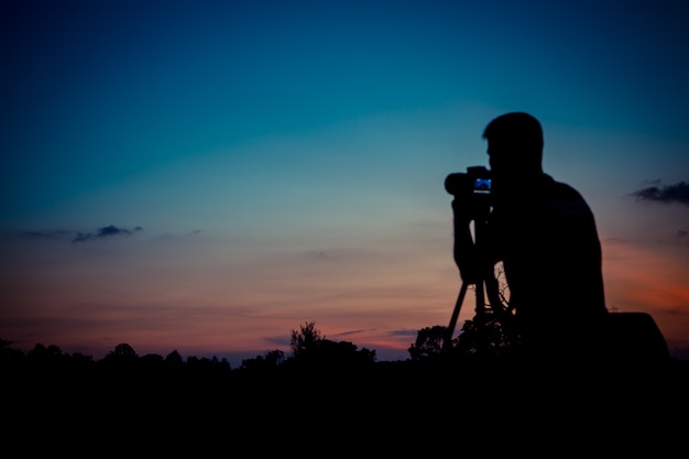 Photographe de silhouette avec fond de coucher de soleil