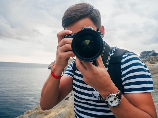 Photographe touriste masculin avec un appareil photo numérique et un grand objectif