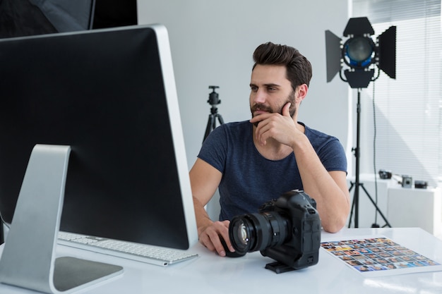 Photographe travaillant sur ordinateur au bureau