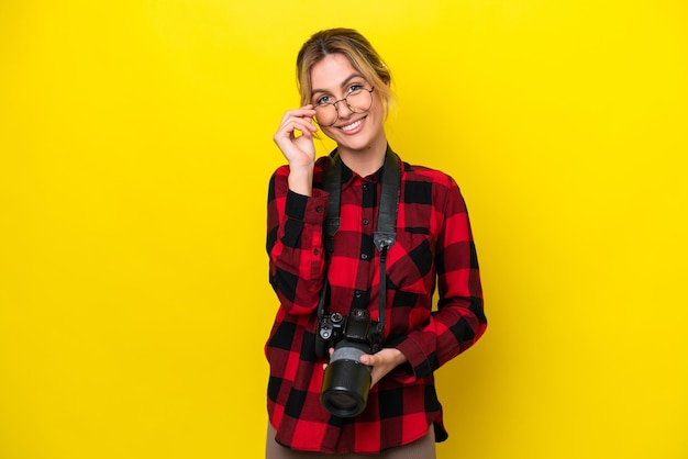 Photographe uruguayen femme isolée sur fond jaune avec des lunettes et heureux