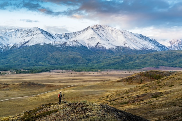 Photographe de voyage au sommet d'une colline dans la steppe de Kurai, vue sur la crête Nord Chuysky. District de Kosh-Agachsky, République de l'Altaï, Russie