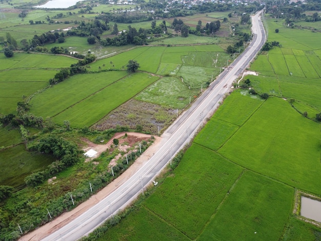 Une photographie aérienne d'une route en construction dans un champ vert.