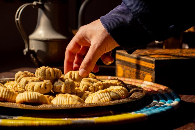 Photographie culinaire pour maamoul pour une main tenant un morceau de maamoul