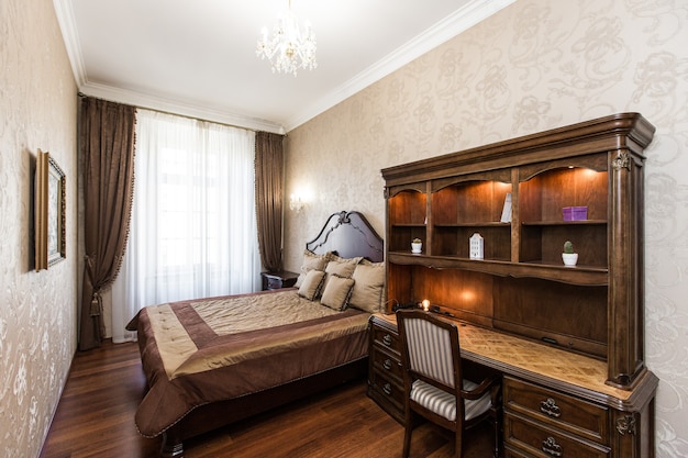 Photographie d'intérieur chambre de luxe avec grand lit en bois de style classique