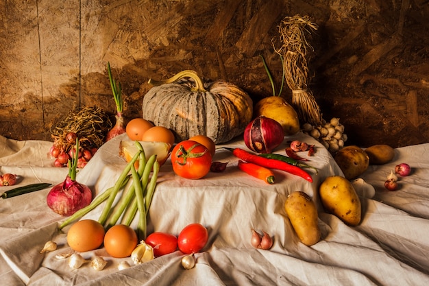 Photographie de nature morte avec citrouille, épices, herbes, légumes et fruits.