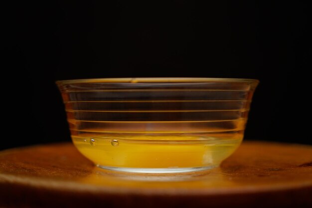 Photo photographie d'un œuf organique cassé dans un récipient en verre sur fond de bois