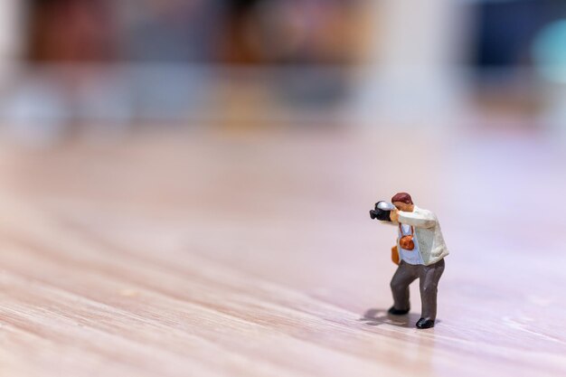 Photo photographie de personnes miniatures tenant un appareil photo et un espace de copie pour le texte