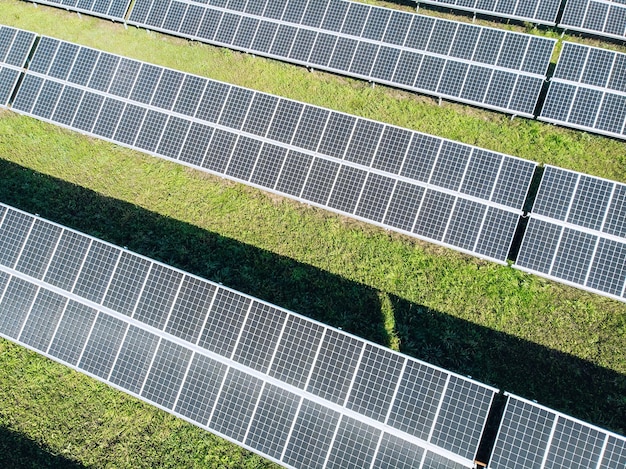 Photovoltaïque solaire de vue aérienne, rangées de plantes solaires sur l'herbe de la ferme. Vue de dessus