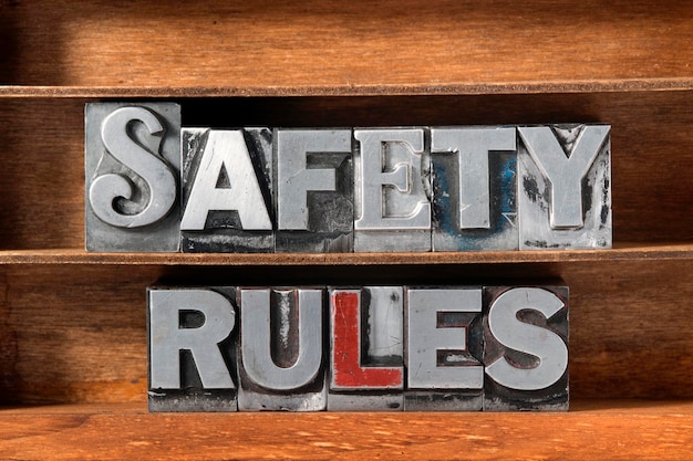 Phrase de règles de sécurité fabriquée à partir de caractères typographiques métalliques sur un plateau en bois