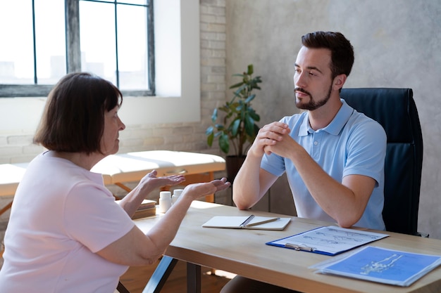 Physiothérapeute discutant avec le patient tir moyen