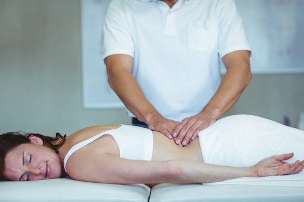 Physiothérapeute donnant un massage du dos à une femme