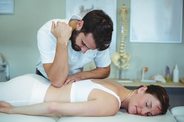 Physiothérapeute donnant un massage du dos à une femme