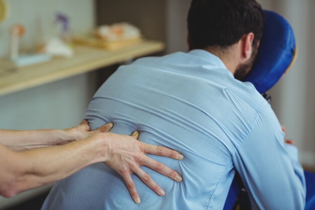 Physiothérapeute donnant un massage du dos à un patient