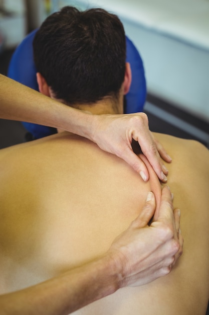 Physiothérapeute donnant un massage du dos à un patient
