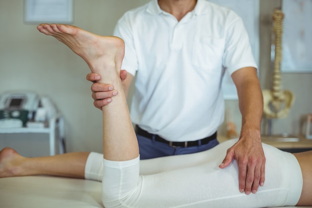 Physiothérapeute donnant un massage des jambes à une femme