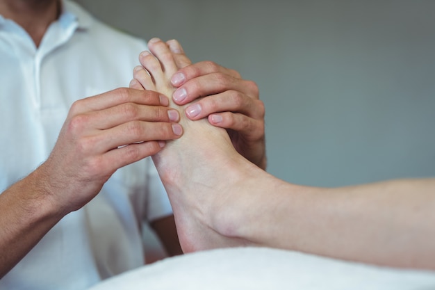 Physiothérapeute donnant un massage des pieds à une femme
