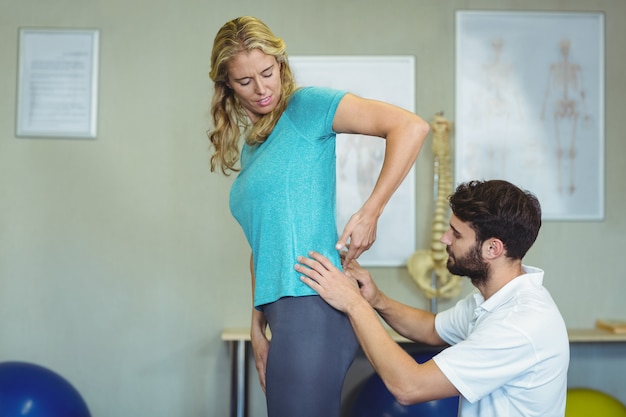 Physiothérapeute examinant le dos de la femme