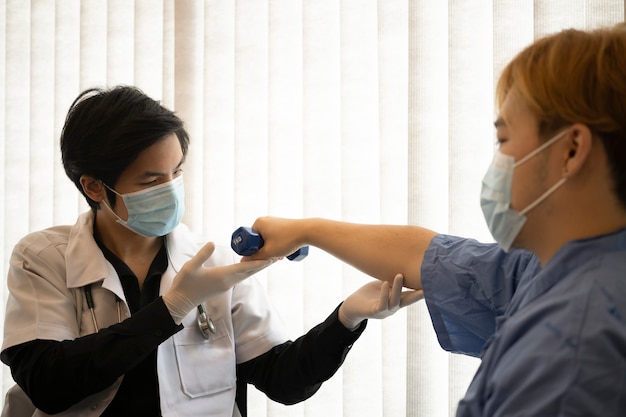 Physiothérapeute examinant le traitement du bras blessé du patient.